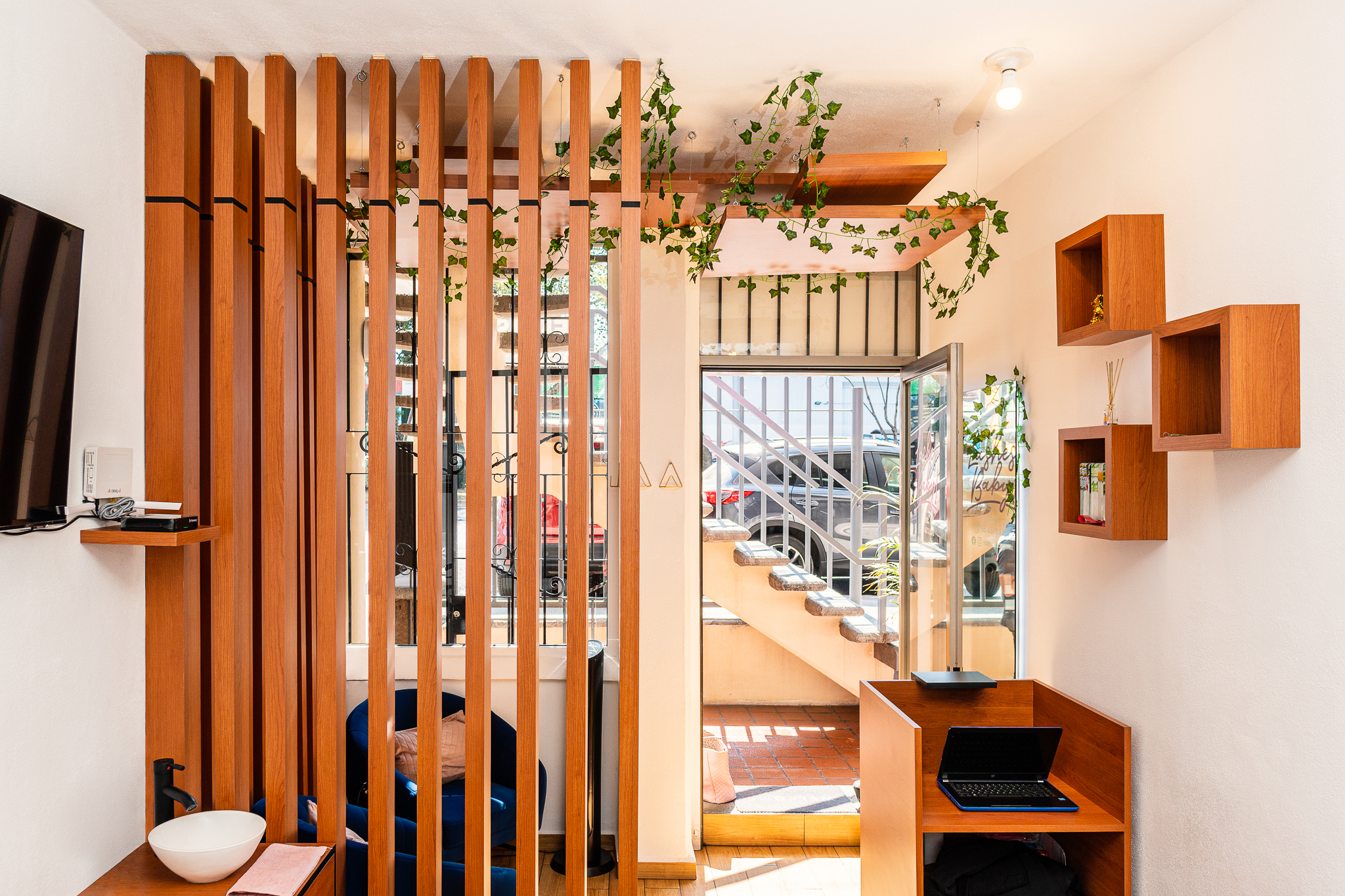 Interiorismo comercial en diseño de salón de pestañas con recepción en madera e iluminación cálida